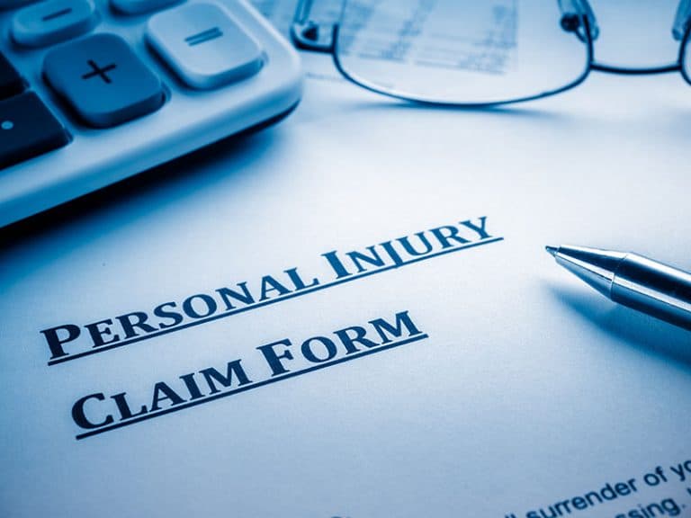 A Personal Injury Claim Form sits on a desk